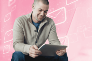 man looking at ipad with pink email notifications as a background