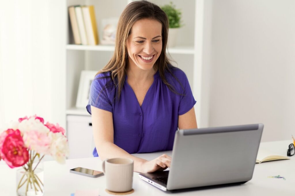woman smiling and working on laptop