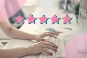 woman typing on laptop with pink review five stars